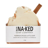 A bar of Buck Naked Soap Company Pumpkin Spiced Latte Soap, featuring a creamy off-white top with light brown pumpkin spice swirls and a cinnamon stick, set in a brown container with a white paper label.